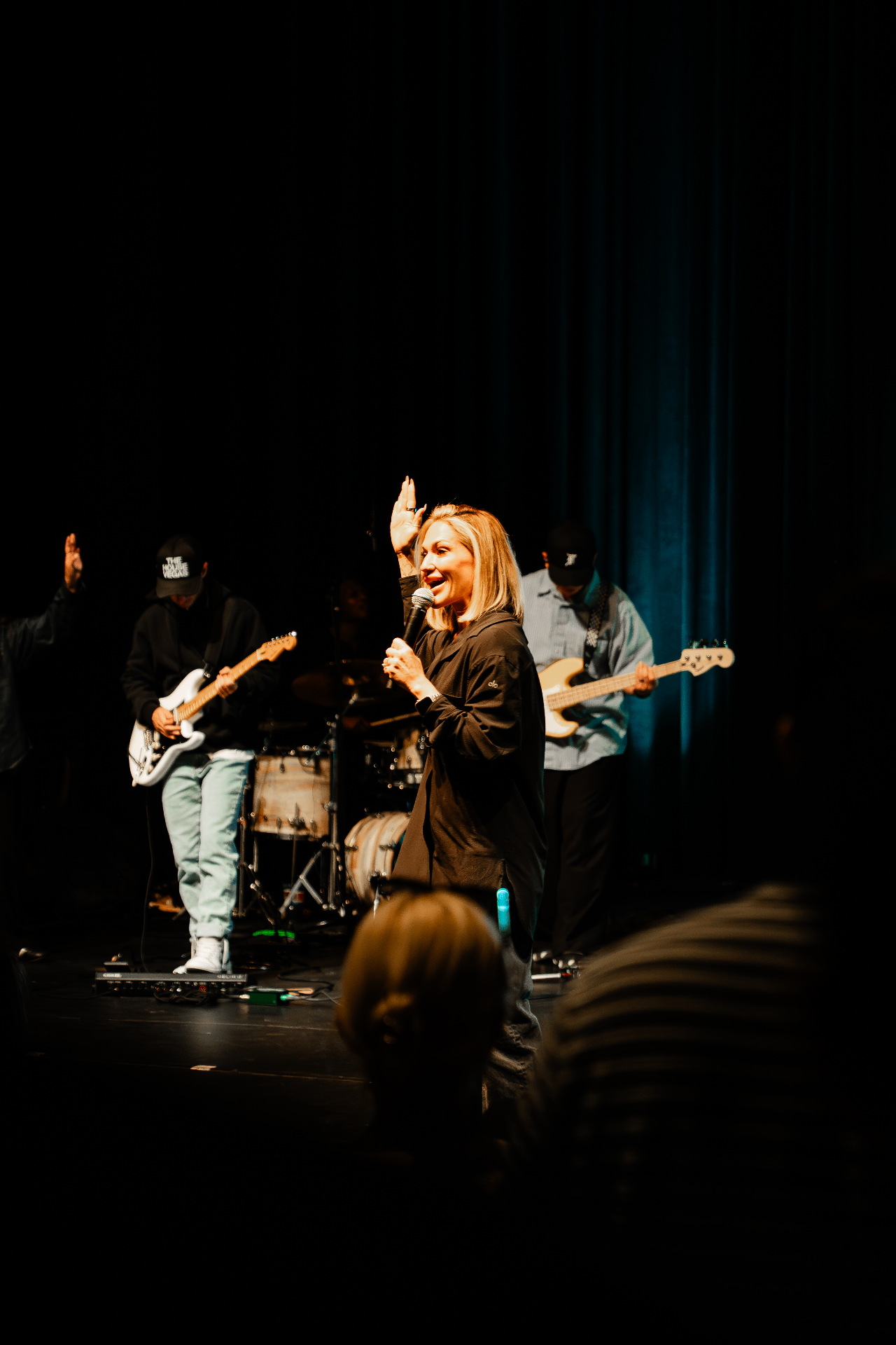 Brittany Powell speaking at a Sunday service with the band behind her